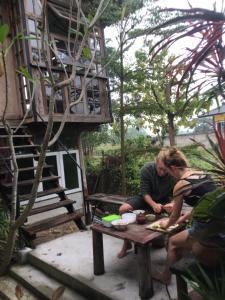 dos personas sentadas en una mesa de picnic en un jardín en Baan Mali Lampang Homestay, en Lampang