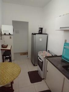 uma pequena cozinha com um frigorífico e uma mesa em Apto 1 dorm. Guarujá - Pitangueiras - perto da praia no Guarujá