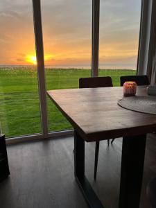 a table in a room with a view of the sunset at Luxus Chalet Meeresweitblick in Westerland +22 photos