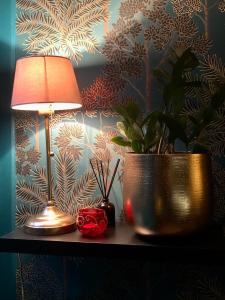 une lampe et une plante en pot sur une table dans l'établissement Reglisse et Pain d'Epices - Chambres d'hôtes, à Honfleur