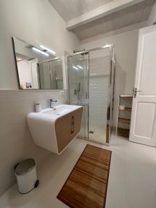 a bathroom with a sink and a shower and a mirror at Suite Battisti 7 in Lecce