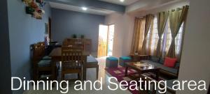 Monshing Homestay - Elevate your travel experience في Bomdila: غرفة معيشة مع منطقة لتناول الطعام والجلوس