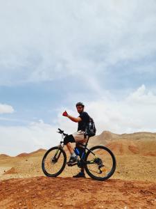 un hombre montando una bicicleta en el desierto en Kasbah Chems, en Kalaat MGouna