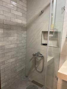 a shower with a glass door in a bathroom at 晶晶輕旅民宿 in Ruifang