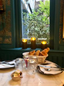 una mesa con un tazón de pan y velas. en Reglisse et Pain d'Epices - Chambres d'hôtes, en Honfleur