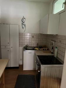 uma cozinha com armários brancos e um forno com placa de fogão em Rubys1 em Frankfurt