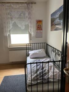 um pequeno quarto com uma cama e uma janela em Rubys1 em Frankfurt