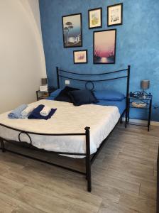 1 dormitorio con 1 cama con pared azul en Marolù Casa Vacanze en Vietri
