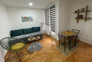 ein Wohnzimmer mit einem Sofa, einem Tisch und Stühlen in der Unterkunft Apartman Kosta in Leskovac