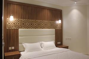1 dormitorio con 1 cama grande y cabecero de madera en التميز الراقي - الفيصلية en Yeda