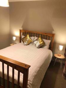 een slaapkamer met een bed met kussens en 2 lampen bij Dunfermline Home with Free Parking Near Amazon & M90 in Dunfermline