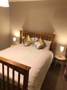 ein Schlafzimmer mit einem Bett mit Kissen und zwei Lampen in der Unterkunft Cosy Home with Free Parking Near Edinburgh St Andrews M90 & Amazon in Dunfermline + 31 Fotos