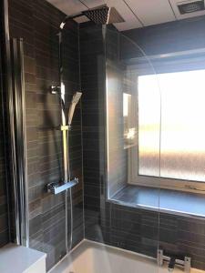 een badkamer met een douche en een glazen deur bij Dunfermline Home with Free Parking Near Amazon & M90 in Dunfermline