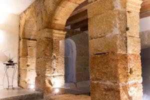 un antiguo arco de piedra en una habitación con mesa en Open Sicily Homes "Residence Guascone" - Self check in, en Palermo