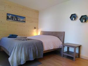 Studio cosy et fonctionnel entre Saule et Lilas في فيلارد دي لانس: غرفة نوم بسرير وطاولة جانبية