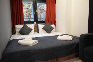 M - Square Private Rooms في إسكوبية: غرفة نوم عليها سرير وفوط