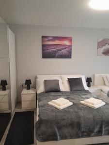a bedroom with a large bed with two towels on it at Apartment Amalia in Varaždin
