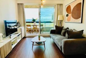 uma sala de estar com um sofá e uma mesa em Alto da Barra 186E - Parking & Sea View em Oeiras