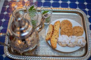 bandeja con una bandeja de galletas y galletas en una mesa en Riad Fes Elite, en Fez