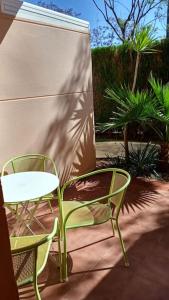 2 Stühle und ein Tisch sowie ein Tisch und Stühle auf einer Terrasse in der Unterkunft Adosado playa Islantilla campo de golf in Huelva