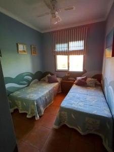 um quarto com 2 camas e uma janela em Adosado playa Islantilla campo de golf em Huelva