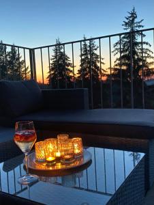 a glass of wine and candles on a table on a balcony at All about the Lake in Staré Splavy