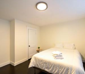 um quarto com uma cama branca e toalhas em Modern Two Bedroom Condo - Boston em Stoneham