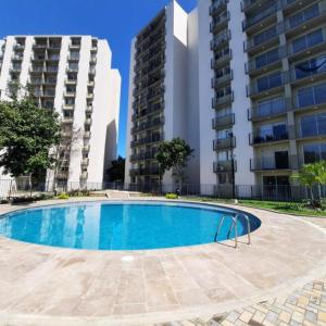 une piscine en face de deux grands bâtiments dans l'établissement Hermoso apto cerca a la playa Bello Horizonte Plaza, à Santa Marta