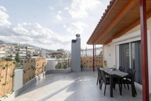 patio con mesa y sillas en el balcón en Deluxe Διαμερισμα en Patras