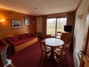 a living room with a couch and a table at Plagne Villages, Charmante Résidence de Tourisme 4 Etoiles in Plagne Villages