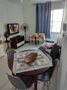 uma sala de estar com uma mesa e um sofá em Apto 1 dorm. Guarujá - Pitangueiras - perto da praia no Guarujá