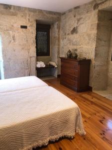 a bedroom with a white bed and a dresser at Casa Lisboana in Pontevedra