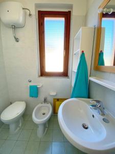 W łazience znajduje się umywalka, toaleta i lustro. w obiekcie Paradise Flat - View, Garden & Parking (200Mt Sea) w mieście Costa Rei