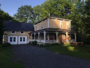 a large house with a porch and a yard at House & loft, pool table, ping-pong, fireplace, AC in Ayer's Cliff