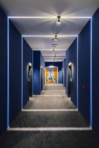un pasillo con paredes azules y una pintura en la pared en Art Magus Hotel, en Sofía