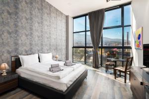 a bedroom with a bed and a large window at Art Magus Hotel in Sofia