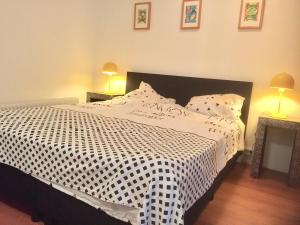 een slaapkamer met een bed met een zwart-wit dekbed bij Big appartment in sunny privat garden in Nijmegen