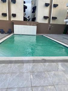 una piscina de agua verde frente a un edificio en Apartamento Esme en Santo Domingo