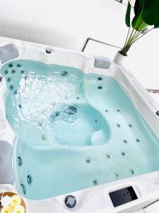a bath tub filled with blue water in a sink at QV Residence Langkawi - Jacuzzi, BBQ, & Steamboat in Kuah
