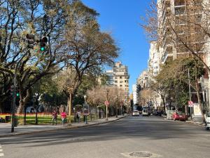 una calle de la ciudad con un semáforo verde y edificios en Apart Plaza Vicente Lopez en Buenos Aires