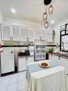 a kitchen with a table with a plate of food on it at QV Residence Langkawi - Jacuzzi, BBQ, & Steamboat in Kuah