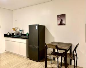 a small kitchen with a table and a refrigerator at Condo in Cebu City Meridian with Netflix and WIFI, near Ayala and IT Park U03 in Cebu City