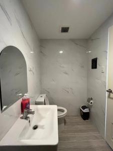 a bathroom with a sink and a toilet and a mirror at Condo in Cebu City Meridian with Netflix and WIFI, near Ayala and IT Park U03 in Cebu City