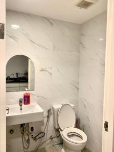 a white bathroom with a toilet and a sink at Condo in Cebu City Meridian with Netflix and WIFI, near Ayala and IT Park U03 in Cebu City
