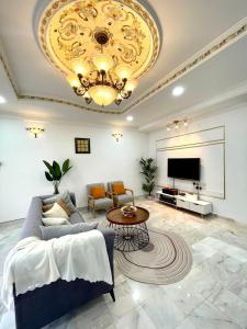a living room with a couch and a chandelier at QV Residence Langkawi - Jacuzzi, BBQ, & Steamboat in Kuah