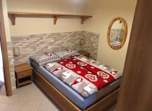 Schlafzimmer mit einem Bett mit roten und weißen Decken in der Unterkunft Appartamento 2 Baita Sosio Livigno in Livigno