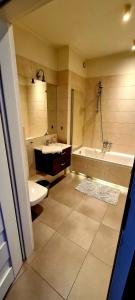 een badkamer met een bad, een wastafel en een toilet bij Twoj Czas in Krakau