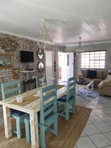 Un comedor y una sala de estar con mesa y sillas. en Whispering waves, en Gamtoosriviermond