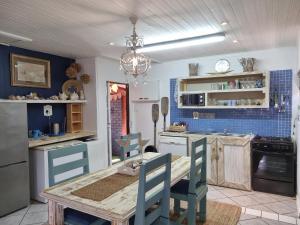 a kitchen with a wooden table and blue tiles at Whispering waves in Gamtoosriviermond