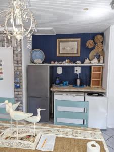 a kitchen with blue walls and a chandelier at Whispering waves in Gamtoosriviermond